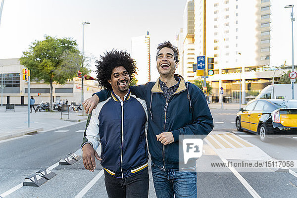 Two happy friends walking in the city  Barcelona  Spain