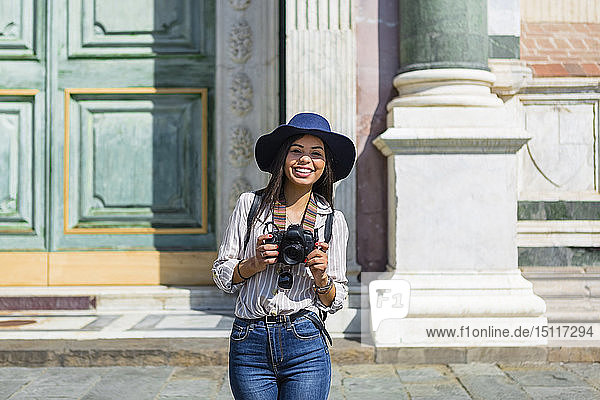 Italy  Florence  portrait of happy young tourist with camera