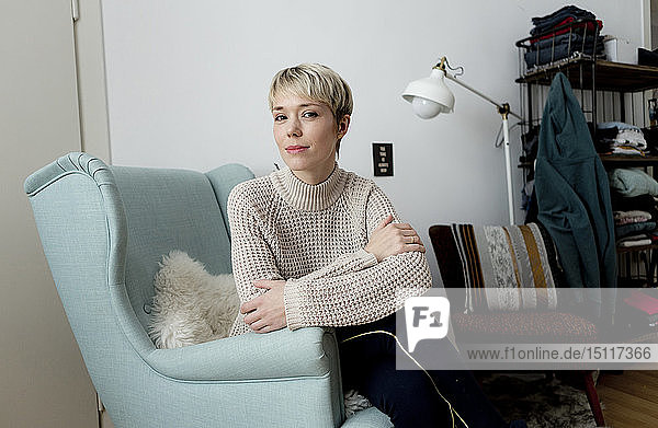 Porträt einer entspannten Frau  die zu Hause in einem Sessel sitzt