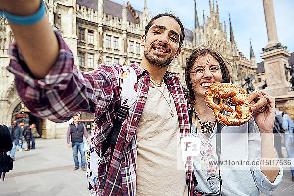 Junges Paar beim Selfie mit Brezel in München  Deutschland