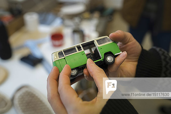 Close-up of woman holding minibus model