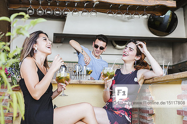 Zwei glückliche Frauen bei einem Drink in einer Bar