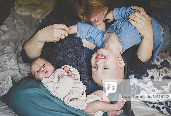 Mutter spielt mit einem Kleinkindsohn und einer neugeborenen Tochter