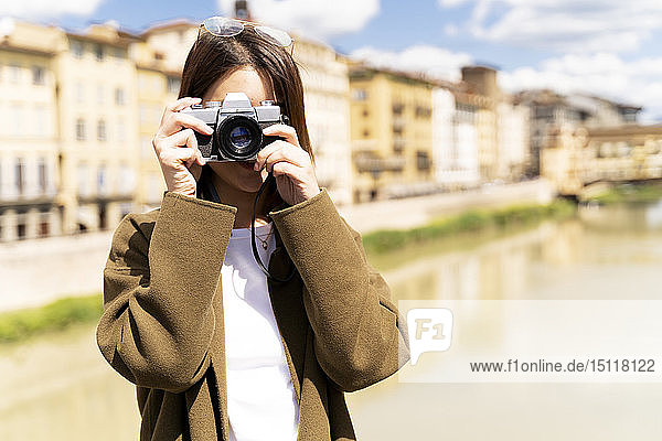 Italy  Florence  young tourist woman taking pictures at Ponte Vecchio