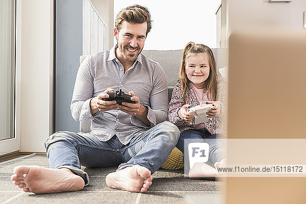 Junger Mann und kleines Mädchen spielen Computerspiel mit Spielkonsole