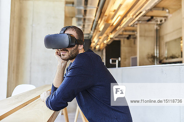 Junger Mann mit VR-Brille im modernen Büro