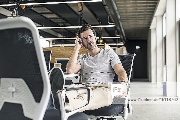Young businessman working relaxed in modern office  thinking