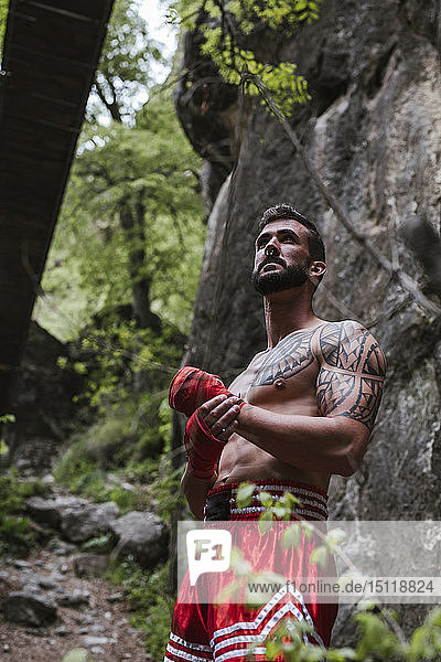 Tattooed boxer standing in nature