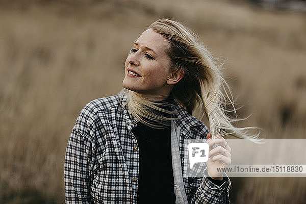 Großbritannien  Schottland  Hochland  Porträt einer lächelnden jungen Frau in einer ländlichen Landschaft