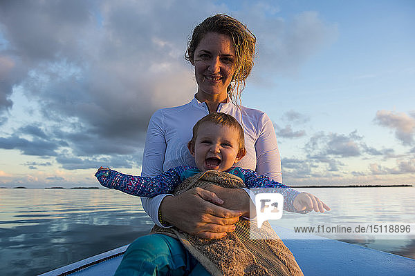 Französisch-Polynesien  Tuamotus  Tikehau  Mutter hält ihr glückliches Baby in einem Boot auf dem Ozean