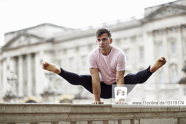 Grossbritannien  London  junger Mann macht vor dem Buckingham-Palast Gymnastikakrobatik