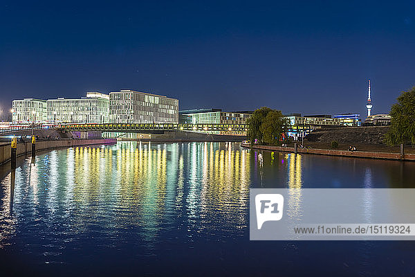 Deutschland  Berlin  Blick auf beleuchtete moderne Gebäude in der Nähe der Spree