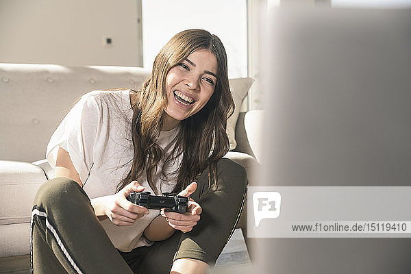 Glückliche junge Frau spielt zu Hause Videospiel