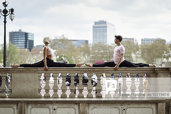 Grossbritannien  London  junges Paar turnt auf der Brüstung des Buckingham-Palastes Akrobatik