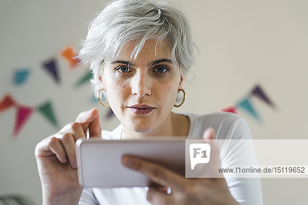 Portrait of woman using cell phone at home