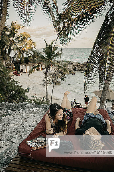 Mexiko  Quintana Roo  Tulum  zwei glückliche junge Frauen  die sich am Strand entspannen