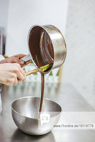 Junior-Chefkoch bereitet ein Dessert zu  Schüssel mit Schokoladensauce