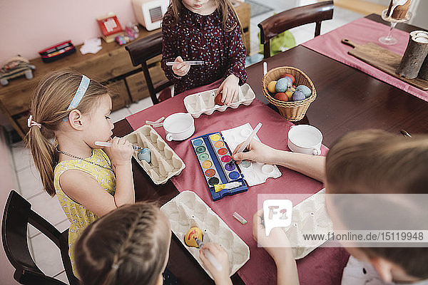 Kinder malen zu Hause Ostereier auf den Tisch