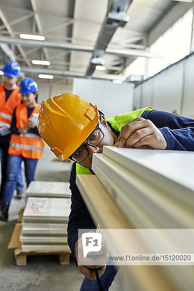 Arbeiter untersucht Holzbretter in der Fabrik