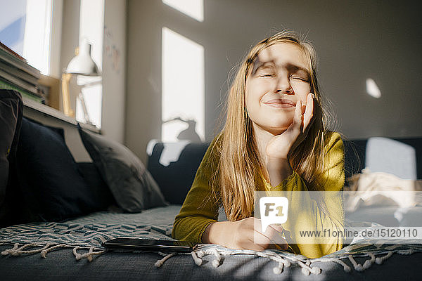 Girl lying on couch at home in sunshine