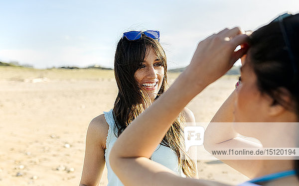 Zwei glückliche Freundinnen am Strand