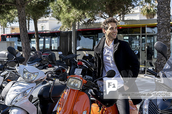 Spanien  Barcelona  glücklicher Mann mit Motorroller in der Stadt