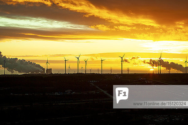 Garzweiler Braunkohleabbau bei Sonnenaufgang mit Windpark im Hintergrund  Juechen  Deutschland