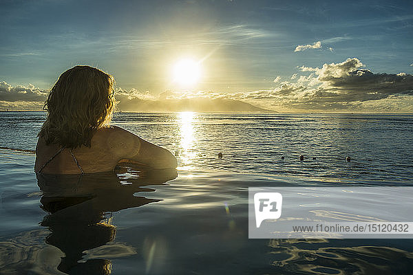 Französisch-Polynesien  Tahiti  Papeete  Frau  die den Sonnenuntergang in einem unendlichen Pool genießt