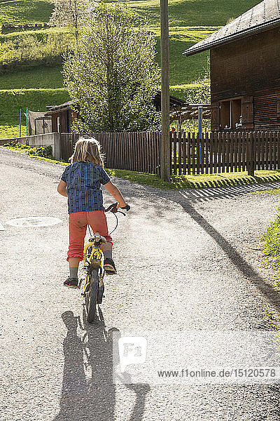 Girl riding bicycle on rural path
