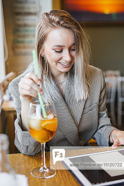 Young businesswoman using tablet in a bar