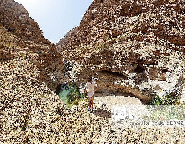 Mann genießt die Aussicht über Wadi Shab  Oman