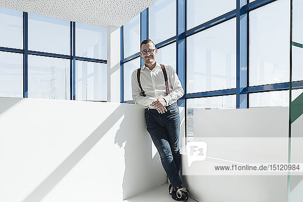 Portrait of confident businessman at the window in modern office