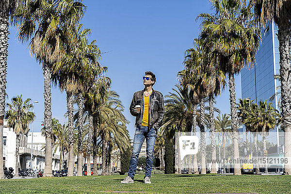 Spain  Barcelona  man standing on lawn in the city looking around