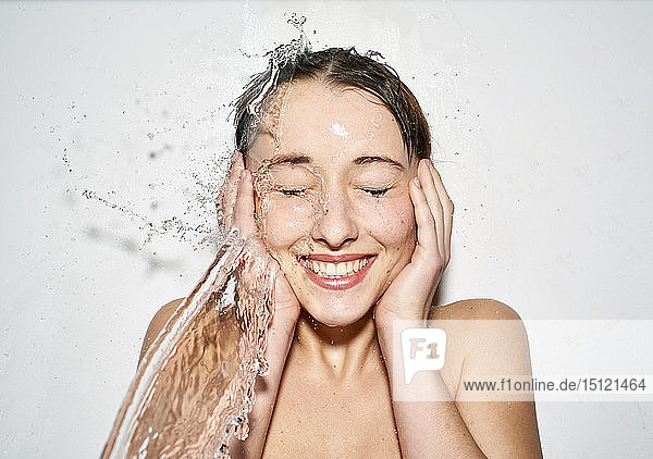 Portrait of laughing young woman with splashing water