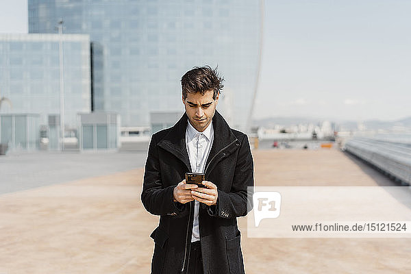 Businessman using cell phone in the city