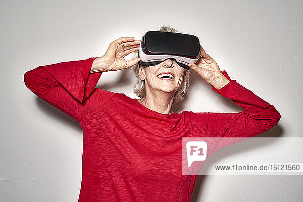 Porträt einer lachenden reifen Frau mit Virtual-Reality-Brille