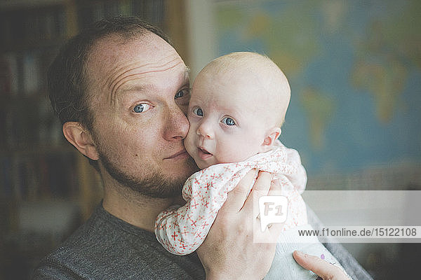 Porträt eines Vaters  der seine kleine Tochter hält