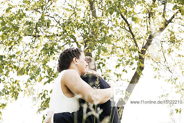 Pregnant bride and her husband on a meadow