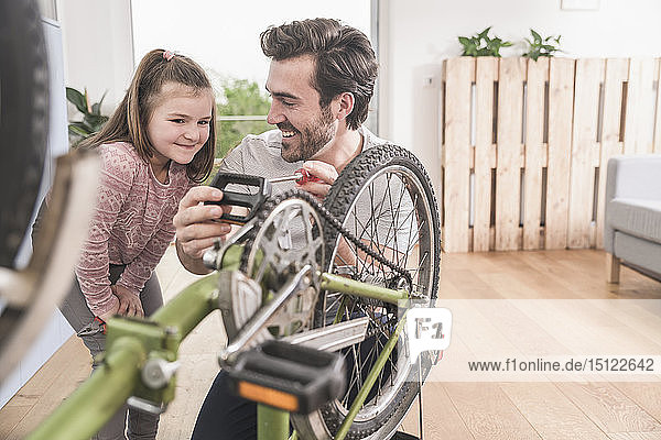 Young man and little girl repairing bicycle together