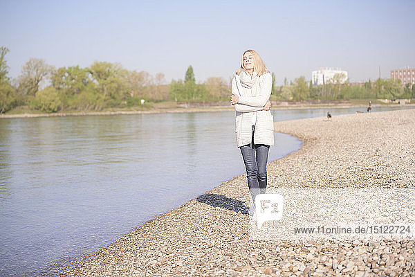Lächelnde reife Frau beim Spaziergang am Flussufer