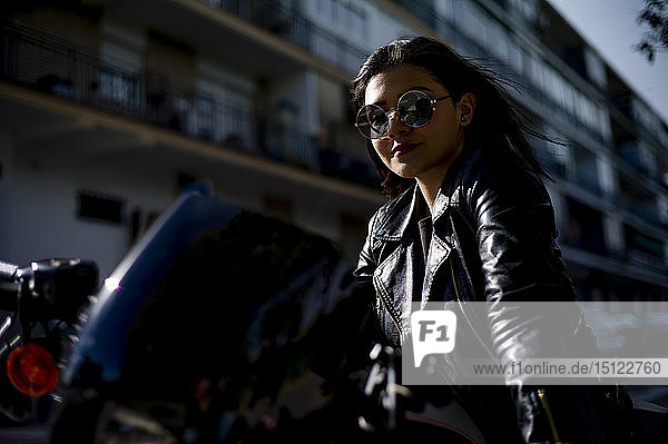 Porträt einer zufriedenen jungen Frau auf Motorrad
