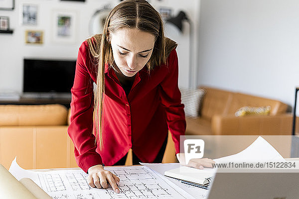 Woman in office working on plan on table