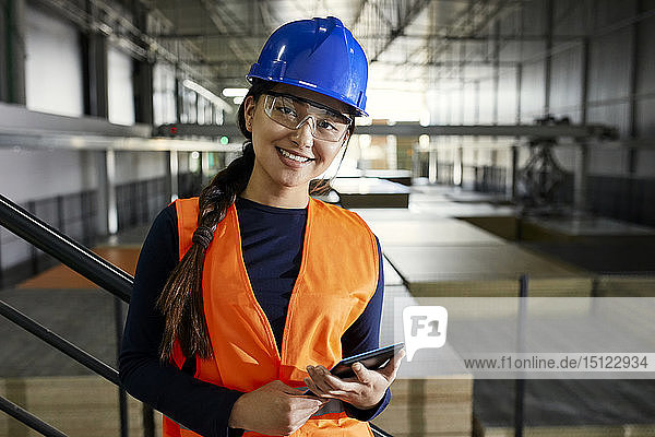 Porträt einer selbstbewussten Arbeiterin in einem Fabriklager