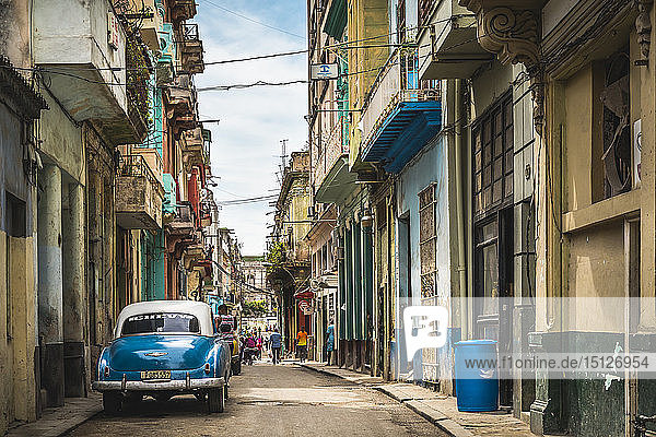 Blauer Oldtimer  geparkt auf einer alten bunten Straße in La Habana  Havanna  Kuba  Westindien  Karibik  Mittelamerika