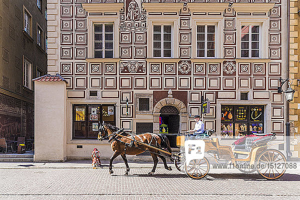 A horse drawn carriage passing beautiful architecture in the old town  UNESCO World Heritage Site  Warsaw  Poland  Europe