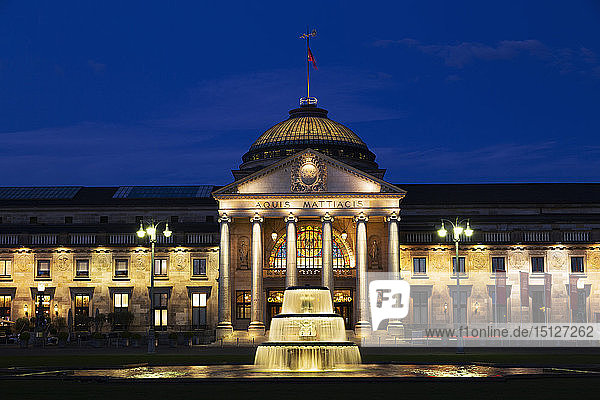 Illuminated fountain at dusk on the Bowling Green in front of the Kurhaus in Wiesbaden Hesse Germany Europe