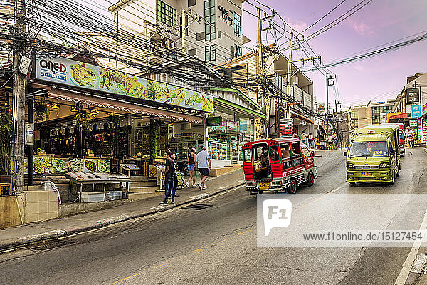 Eine Straßenszene und lokale Taxis und Tuk Tuks in Kata  Phuket  Thailand  Südostasien  Asien