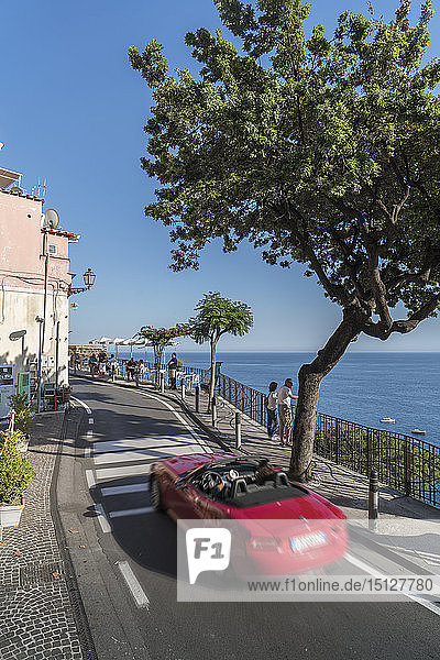 Roter Sportwagen auf der engen Straße der Amalfiküste  UNESCO-Weltkulturerbe  Kampanien  Italien  Europa