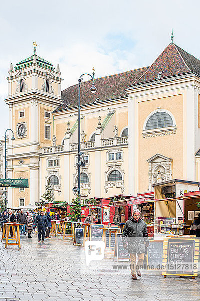 Der Weihnachtsmarkt auf der Freyung mit der katholischen Schottenkirche im Hintergrund  Wien Innenstadt  Österreich  Europa