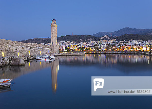 Blick über den Venezianischen Hafen in der Abenddämmerung  Leuchtturm aus dem 16. Jahrhundert spiegelt sich im Wasser  Rethymno (Rethymnon)  Kreta  Griechische Inseln  Griechenland  Europa